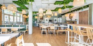 aménagement restaurant, architecte d'intérieur gironde, banquette, chaise haute, claustra, claustra bois, claustra restaurant, décoration restaurant, luminaire cannage, luminaire rotin, papier peint, papier peint végétal, papier peint vert, plafond végétal, plante suspendu, rénovation restaurant, rénovation tresses, restaurant, rotin, table bois, architecte d'intérieur tresses, architecte d'intérieur bordeaux