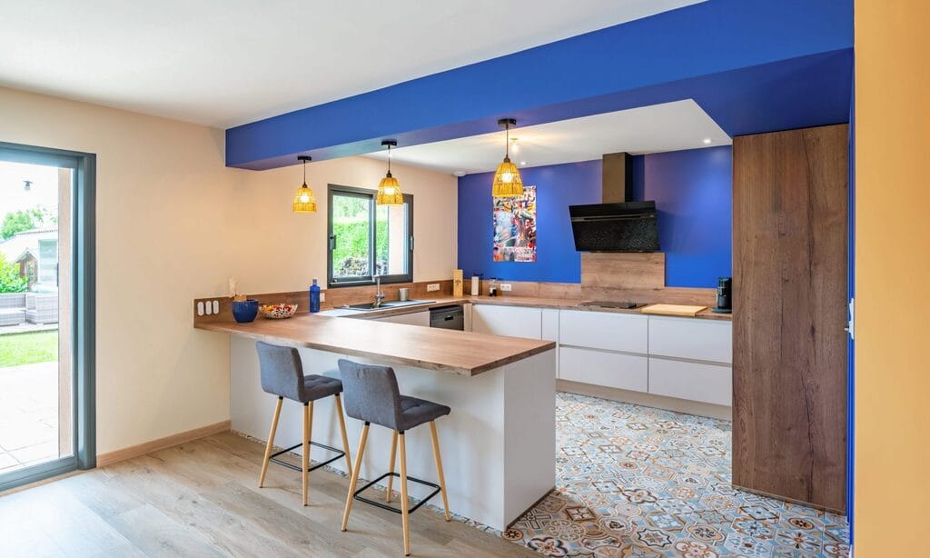 Accueil Cuisine sur-mesure à Saint Loubès : sol carrelage imitation carreaux de ciment, bleu sardaigne et mobilier beige clair et bois foncé.