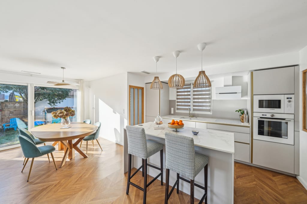 Cuisine ouverte rénovée dans une maison à Mérignac avec mobilier sur-mesure et pièce de vie lumineuse