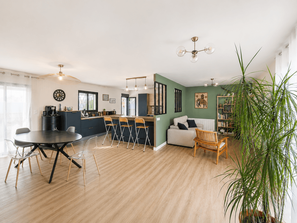 Vue sur l'espace de vie d'une maison à Villenave d'Ornon entièrement rénovée. Séparation entre la cuisine et le salon et jeu de couleur pour dissocier les espaces.